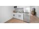 Modern kitchenette featuring white cabinets, stainless steel appliances, and hardwood floors at 857 Athens Dr # 102, Raleigh, NC 27606