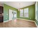 Bright dining area with slider to the outside has green accent wall and chandelier at 88 Antler Steel Dr, Clayton, NC 27527