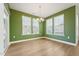 The dining room has a green accent wall, light wood floors, and two bright windows at 88 Antler Steel Dr, Clayton, NC 27527