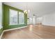 Open-concept living room has light hardwood floors, green accent wall, and lots of natural light at 88 Antler Steel Dr, Clayton, NC 27527