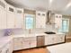 The stunning kitchen is equipped with white cabinets, stainless steel appliances, and a farmhouse sink at 98102 Drummond, Chapel Hill, NC 27517