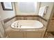 A luxurious white soaking tub is framed by a tiled backsplash and a bright window at 1017 Payton Ct, Raleigh, NC 27614