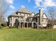 Expansive backyard view of brick home with multiple decks and lush green lawn at 1017 Payton Ct, Raleigh, NC 27614