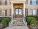 Elegant stone steps lead to an arched, wood and glass front door framed by white columns at 1017 Payton Ct, Raleigh, NC 27614