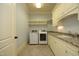 Spacious laundry room with modern washer and dryer, sink and storage cabinets at 1017 Payton Ct, Raleigh, NC 27614