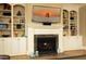 Bright living room featuring a fireplace with built-in shelving and a large screen television at 1017 Payton Ct, Raleigh, NC 27614