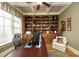 Executive office featuring custom built-in bookshelves, a large desk, and natural light at 1017 Payton Ct, Raleigh, NC 27614