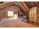 Unfinished attic space with exposed beams, insulation, and storage containers at 104 Spooner Ct, Holly Springs, NC 27540