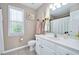 Well-lit bathroom with a white vanity, decorative mirror, and neutral tile flooring at 104 Spooner Ct, Holly Springs, NC 27540