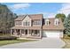 Charming two-story home featuring a welcoming front porch, attached garage, and well-maintained landscaping at 104 Spooner Ct, Holly Springs, NC 27540