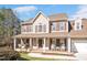 Beautiful two-story home featuring a covered front porch, attached garage, and well-manicured landscaping at 104 Spooner Ct, Holly Springs, NC 27540