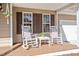 Inviting front porch features classic rocking chairs, decorative cushions, and stylish shutters at 104 Spooner Ct, Holly Springs, NC 27540