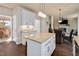 Open kitchen area with center island, granite countertops, stainless appliances, and wood floors at 104 Spooner Ct, Holly Springs, NC 27540