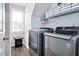 Efficient laundry room with modern silver washer and dryer units and storage shelves at 104 Spooner Ct, Holly Springs, NC 27540