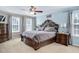 Elegant main bedroom boasts a large carved wood bed frame, plush bedding, and lots of natural light at 104 Spooner Ct, Holly Springs, NC 27540