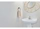 Modern powder room features a pedestal sink, decorative mirror, and a clean, minimalist design at 104 Spooner Ct, Holly Springs, NC 27540