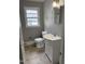 Modest bathroom featuring a white sink, toilet, neutral walls, and a window for natural light at 105 S Elizabeth St, Henderson, NC 27536