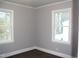 Bedroom with wood-look floors, freshly painted walls and natural light from two windows at 105 S Elizabeth St, Henderson, NC 27536