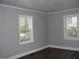 Inviting bedroom featuring durable flooring, neutral walls, and two bright windows at 105 S Elizabeth St, Henderson, NC 27536