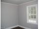 Bedroom with fresh paint, wood-look floors and a large window at 105 S Elizabeth St, Henderson, NC 27536