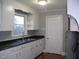 The kitchen features a classic sink, white cabinets, and durable countertops with gray walls at 105 S Elizabeth St, Henderson, NC 27536