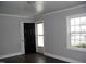 Bright living room featuring sleek, dark flooring, fresh paint, and natural light through a window at 105 S Elizabeth St, Henderson, NC 27536