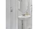 Clean half-bath featuring white walls, a pedestal sink, a round mirror, and chrome fixtures at 109 Perignon Dr, Princeton, NC 27569