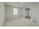 Carpeted room with natural light from window and glass paneled door allowing access to additional rooms at 1414 Excelsior Grand Ave, Durham, NC 27713