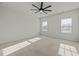 Bright bedroom with ceiling fan, neutral tones, carpeted floor and two large windows at 1414 Excelsior Grand Ave, Durham, NC 27713