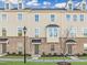 Charming townhome featuring a brick facade, covered doorways, and beautifully landscaped front yard at 1414 Excelsior Grand Ave, Durham, NC 27713
