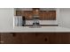 A kitchen island with stainless sink, white countertop, and brown cabinets at 1414 Excelsior Grand Ave, Durham, NC 27713