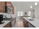 Modern kitchen featuring stainless steel appliances, wooden cabinetry, and bright white countertops at 1414 Excelsior Grand Ave, Durham, NC 27713