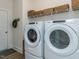 Laundry room with a side by side washer and dryer, a metal rack with decorative baskets above at 142 Sugar Pine Drive, Franklinton, NC 27525