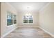 Dining room with new floors, modern chandelier, large windows overlooking the green trees in the back yard at 1987 Meadowview Dr, Graham, NC 27253