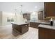 Modern kitchen with an island, stainless steel appliances, granite countertops, and ample dark wood cabinetry at 1987 Meadowview Dr, Graham, NC 27253