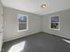 Bright bedroom featuring two windows and neutral-colored walls and carpet at 207 Lawrence St, Fuquay Varina, NC 27526