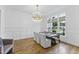 Elegant dining room featuring wood floors, a modern chandelier, wainscoting, and large windows for natural light at 240 Seaforth Landing Dr, Pittsboro, NC 27312
