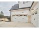 Three car garage featuring white doors with black hardware and brick accents at 240 Seaforth Landing Dr, Pittsboro, NC 27312