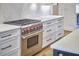 Close-up shot of a stainless steel Wolf oven and gas range with herringbone backsplash and white cabinets at 240 Seaforth Landing Dr, Pittsboro, NC 27312