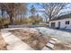 Exterior view of the house with a backyard, driveway, and lush trees at 2504 E East Geer St, Durham, NC 27704
