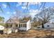 Charming home with a cozy front porch and white siding, complemented by a detached garage at 2504 E East Geer St, Durham, NC 27704