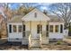 Cozy home with a welcoming porch, updated concrete stairs, and stylish black shutters at 2504 E East Geer St, Durham, NC 27704