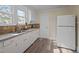 Bright kitchen features neutral countertops, white cabinets and stainless steel sink at 2504 E East Geer St, Durham, NC 27704