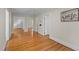 Bright living room showing the hardwood floors and neutral paint, with views of multiple entryways at 2504 E East Geer St, Durham, NC 27704