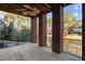 Covered back porch with brick columns and a ceiling fan, overlooking a wooded area at 2600 Buckingham Dr, Sanford, NC 27330