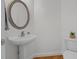 This powder room features a pedestal sink and a stylish round mirror at 2600 Buckingham Dr, Sanford, NC 27330