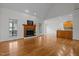 Cozy living room with hardwood floors, a fireplace, and views into the kitchen and backyard at 2600 Buckingham Dr, Sanford, NC 27330