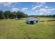Aerial view of a charming white farm structure set amidst open land and blue skies at 2609 Pleasant Hill Liberty Rd, Liberty, NC 27298