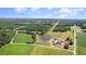 Expansive aerial view of a property featuring lush green fields, a pond, and a charming home nestled in a rural landscape at 2609 Pleasant Hill Liberty Rd, Liberty, NC 27298