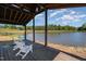 Picturesque covered dock view with white Adirondack chairs overlooking the serene lake at 2609 Pleasant Hill Liberty Rd, Liberty, NC 27298